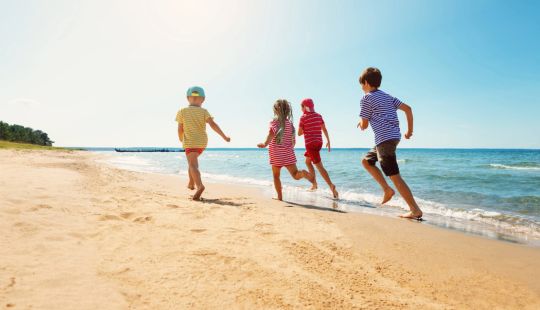 Kinder spielen am Strand von Zinnowitz sicher mit dem Kindersucharmband – hier findet ihr alle Infos für einen sicheren Familienurlaub!